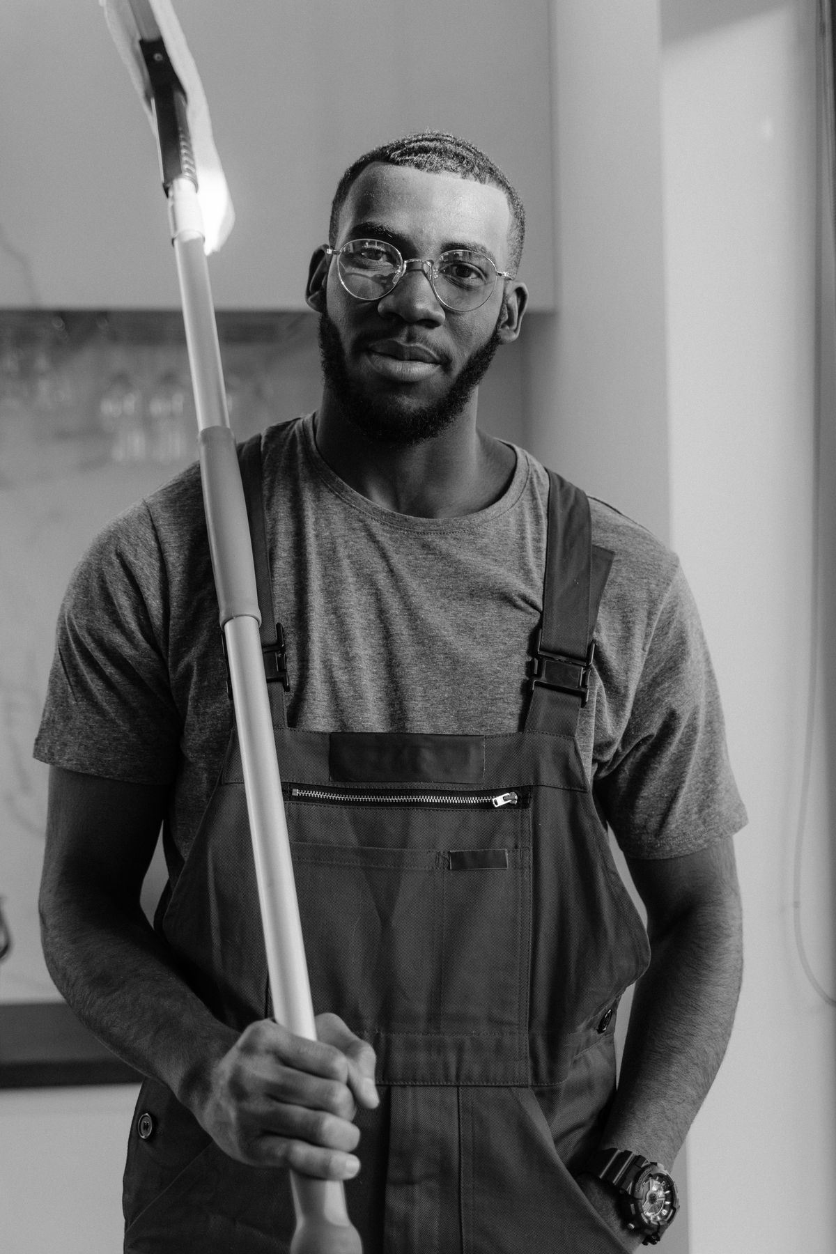 Professional cleaner holding a mop in a bright kitchen
